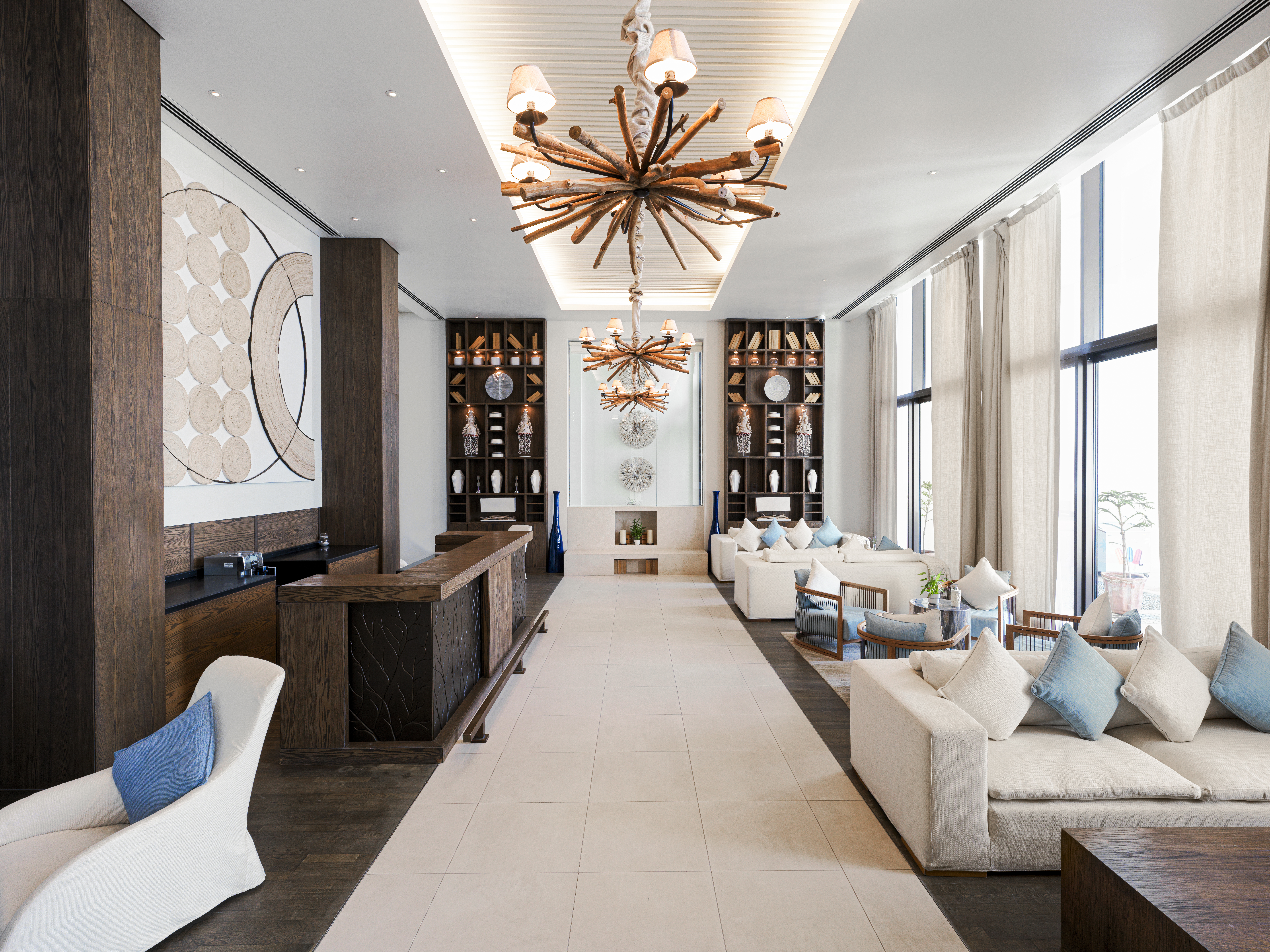 Reception area at Saadiyat Beach Club featuring driftwood lights, creating a warm and inviting atmosphere.